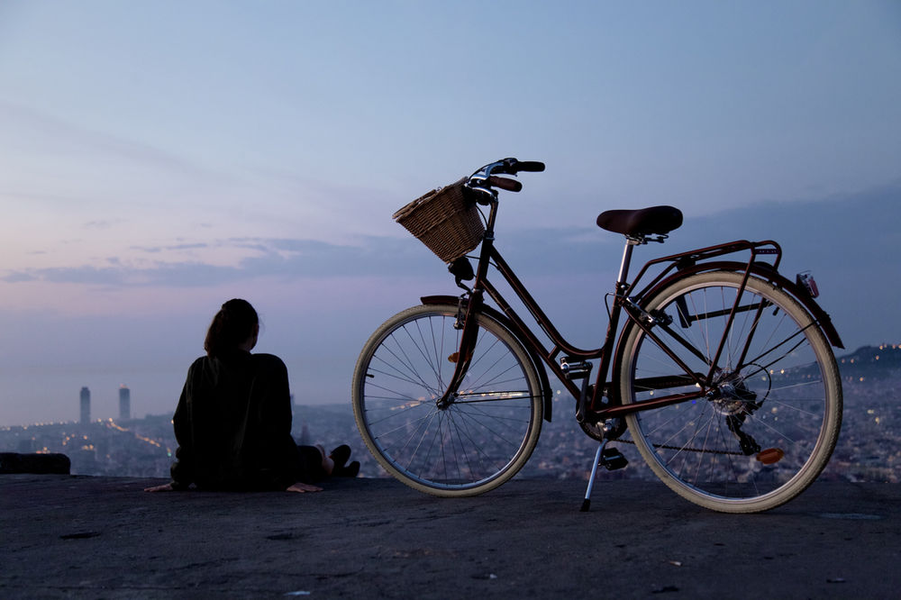 Woman overlooking the city by night