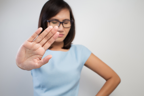 A woman of asian background says no with her hand