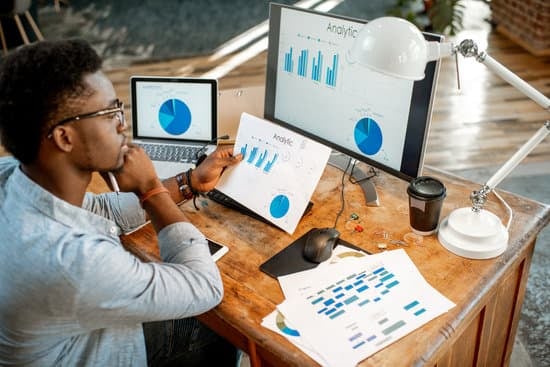 A guy sitting in front of a computer looking at statistics